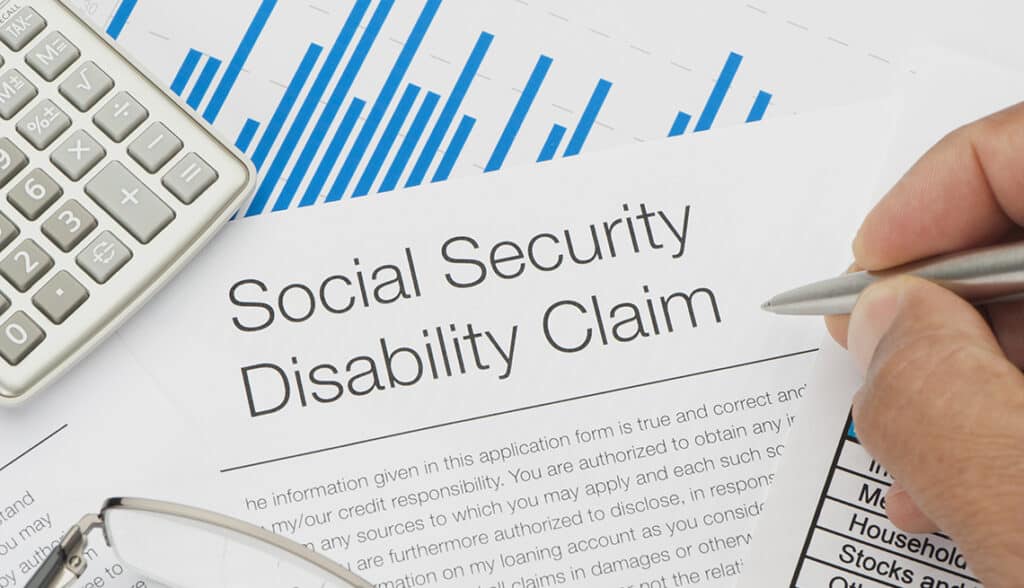 Close up of Social Security Disability Claim Form with writing hand
